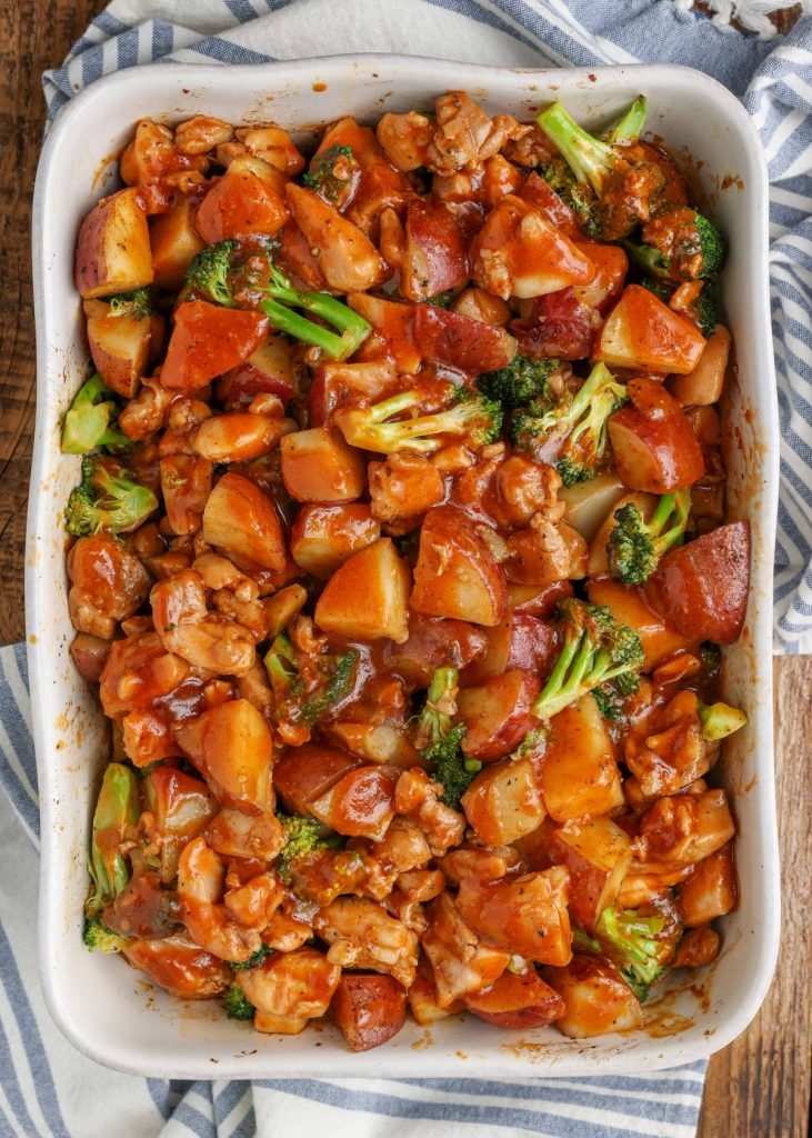 barbecue chicken with broccoli and potatoes in baking dish