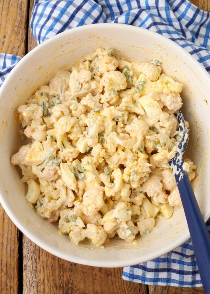 cauliflower potato salad in large bowl with spoon