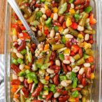 Three bean salad in glass dish with spoon