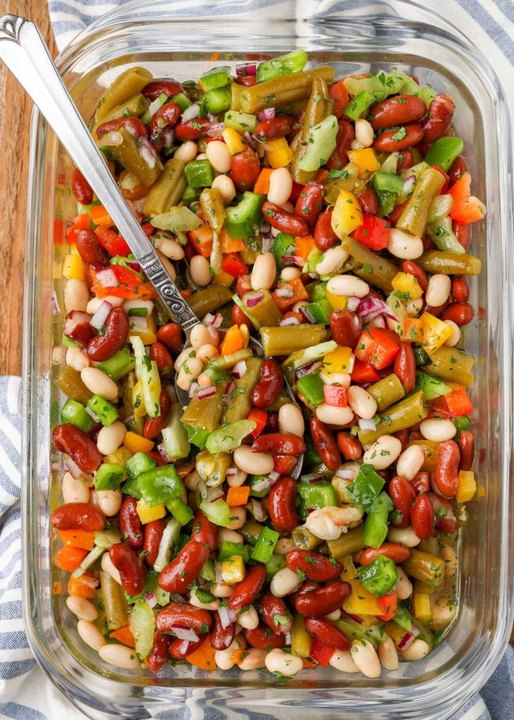 Three bean salad in glass dish with spoon