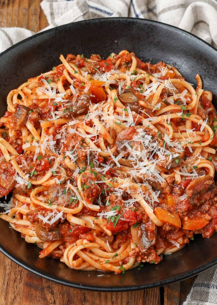 pasta in black bowl tossed with spaghetti mushroom sauce
