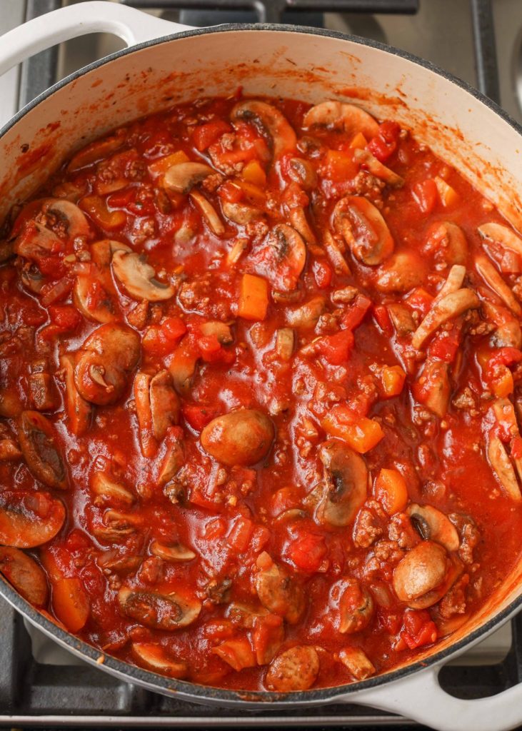 simmering spaghetti sauce with mushrooms on stovetop