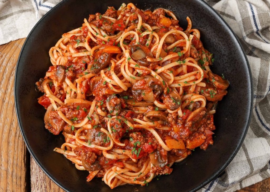 pasta in black bowl with tomato mushroom sauce