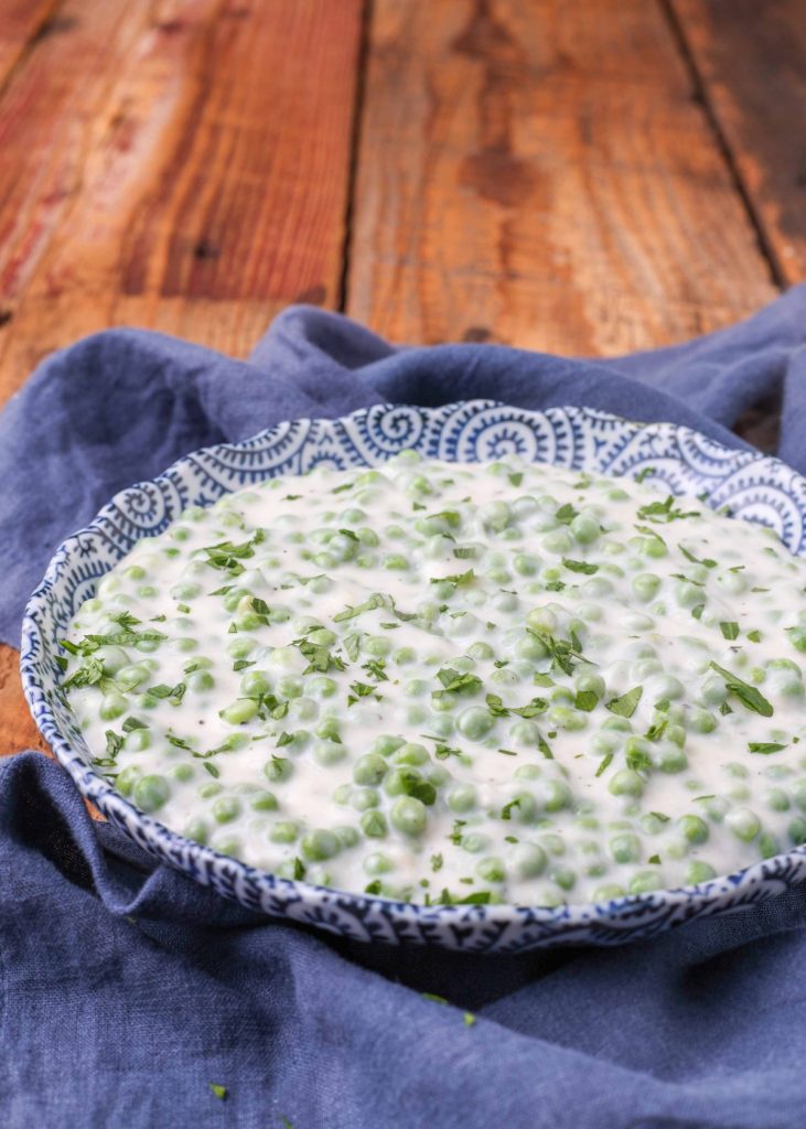 Creamed Peas in blue bowl on blue napkin