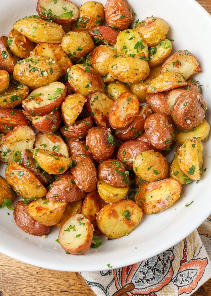 A top down image of a mountain of Garlic Herb Roasted Potatoes in a white bowl.
