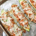 BBQ Chicken filled zucchini boats on sheet pan with towel