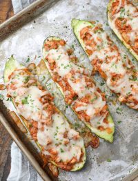 BBQ Chicken filled zucchini boats on sheet pan with towel