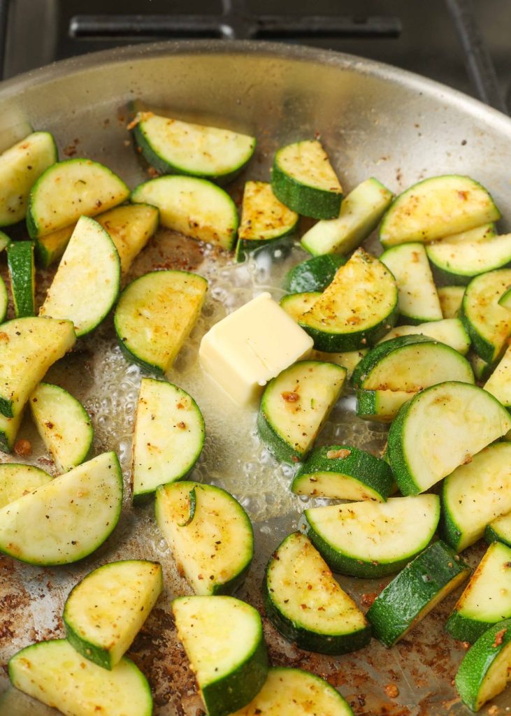 butter melting in skillet with zucchini