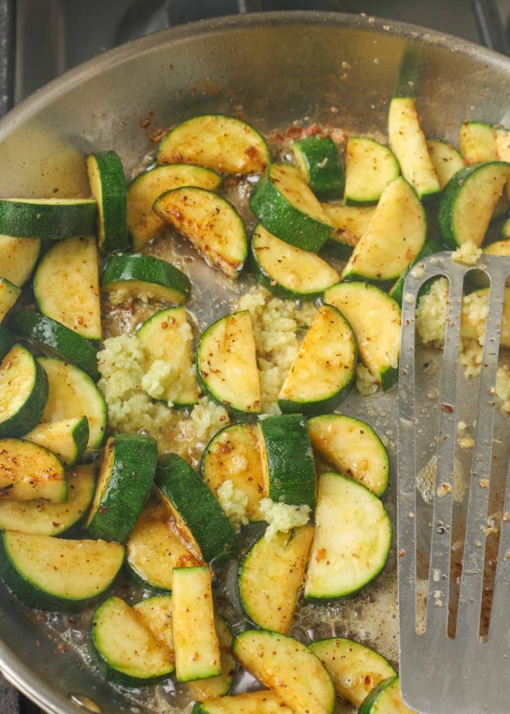 zucchini and minced garlic in stainless pan