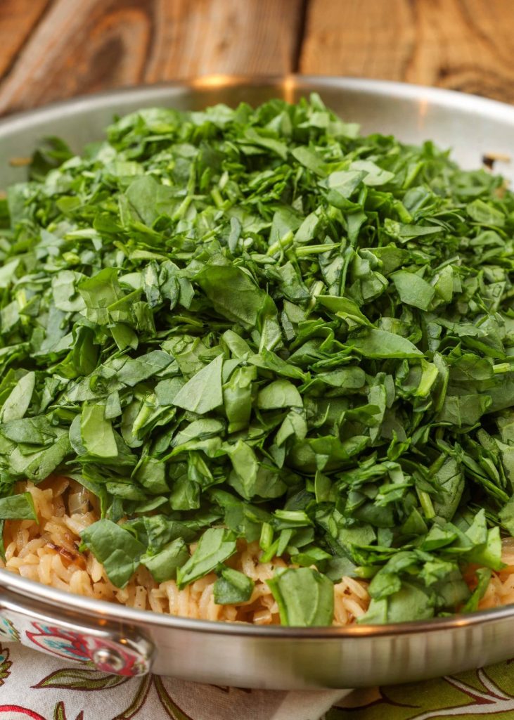 rice with fresh spinach in large pan
