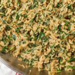 creamy rice with spinach in skillet with tea towel