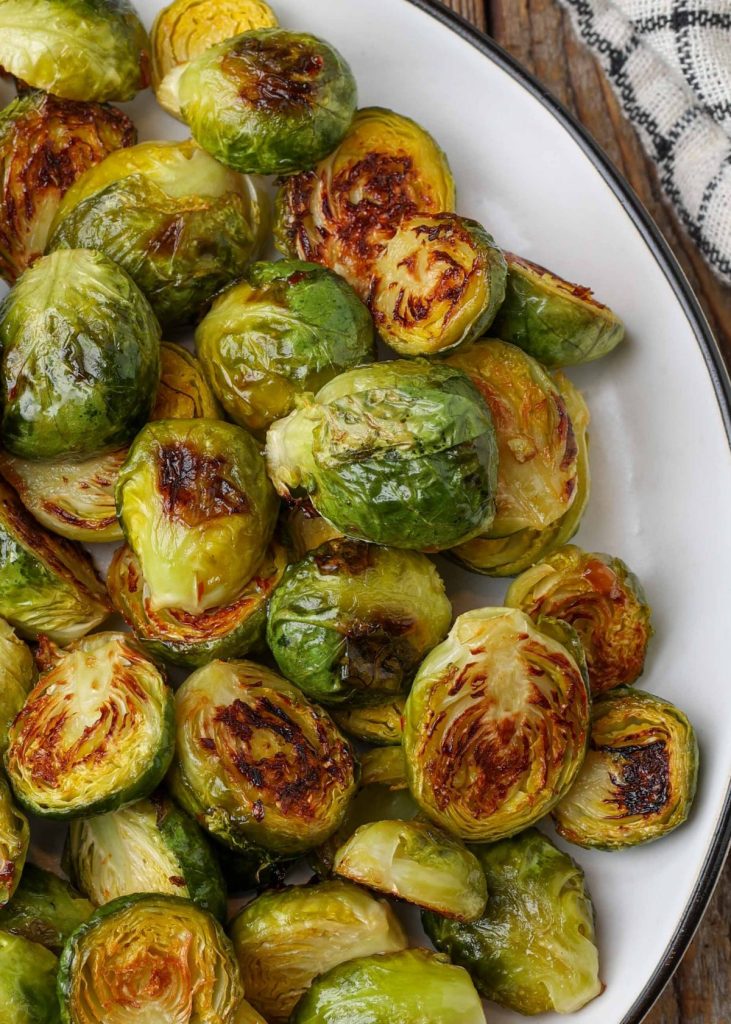 roasted Brussels on white plate with black rim