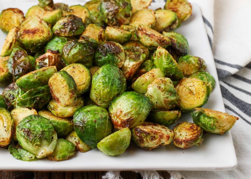 roasted Brussels on square plate with striped napkin