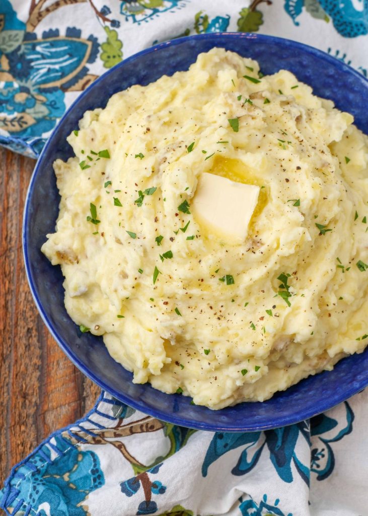 mashed potatoes with butter and herbs in blue bowl