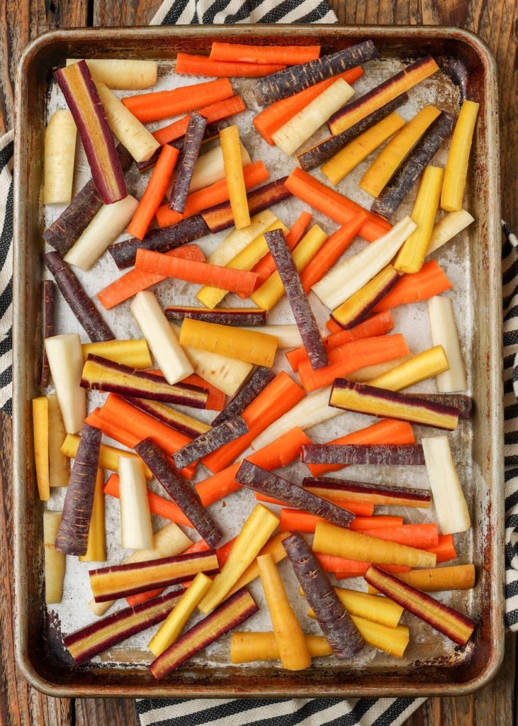 raw rainbow carrots on sheet pan