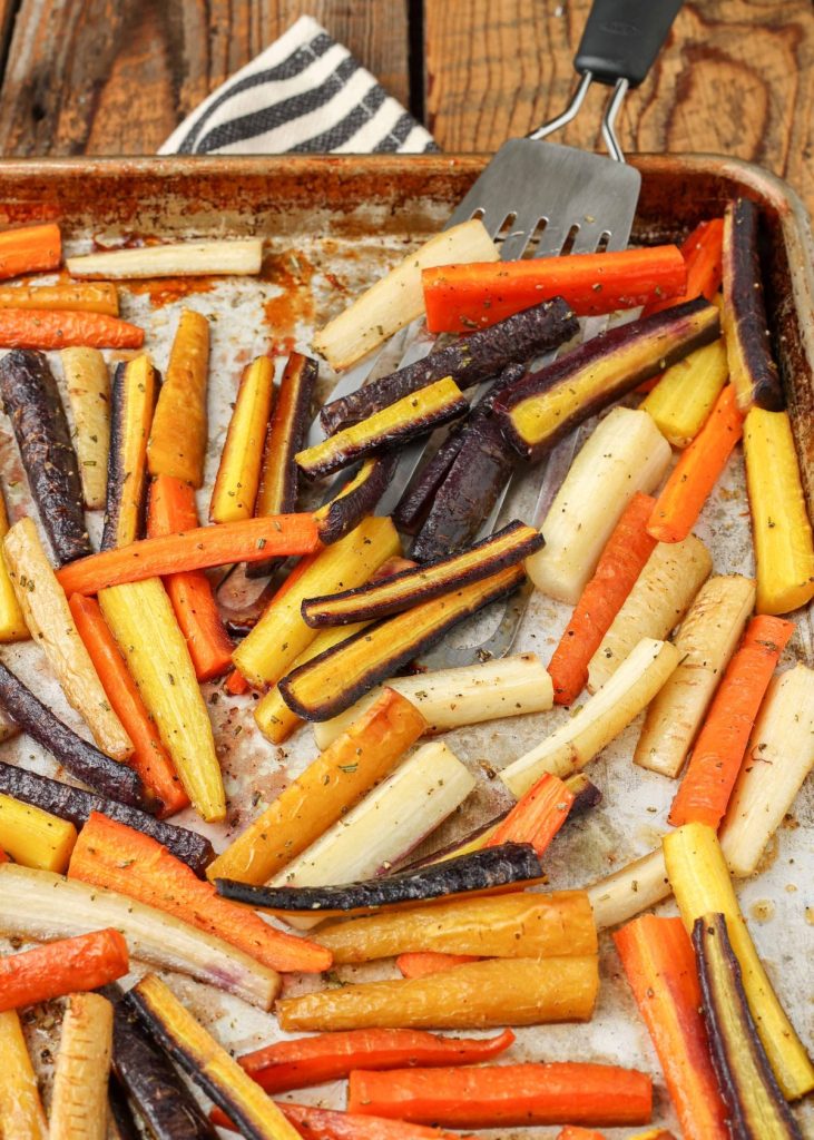 Roasted rainbow carrots on sheet pan with spatula
