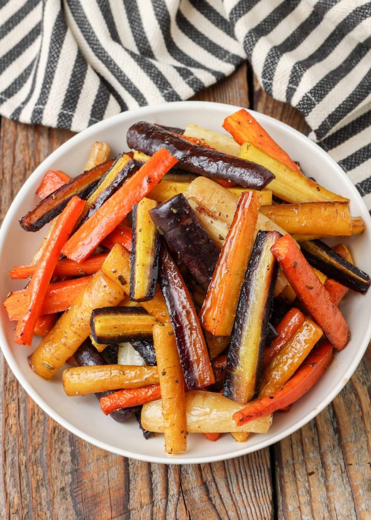 Roasted multi-color carrots in white serving dish