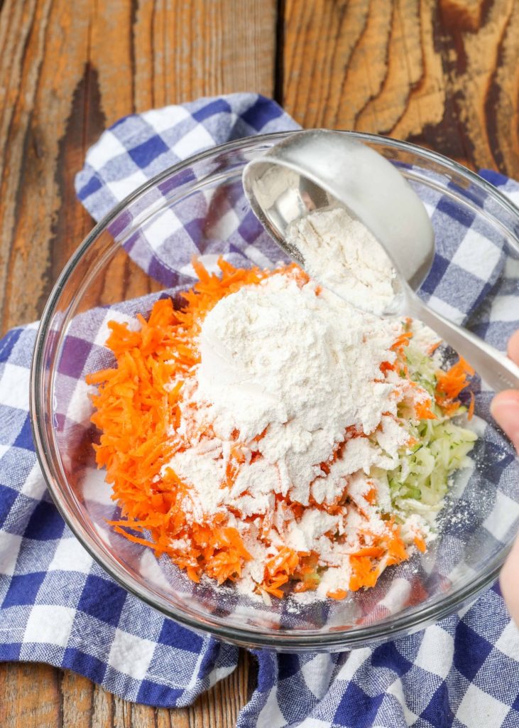 shredded carrots and zucchini with flour in bowl
