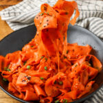 A fork shows the long thin ribbons of carrot in this salad.