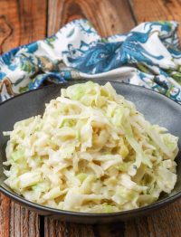 Creamed Cabbage in black bowl with wooden table