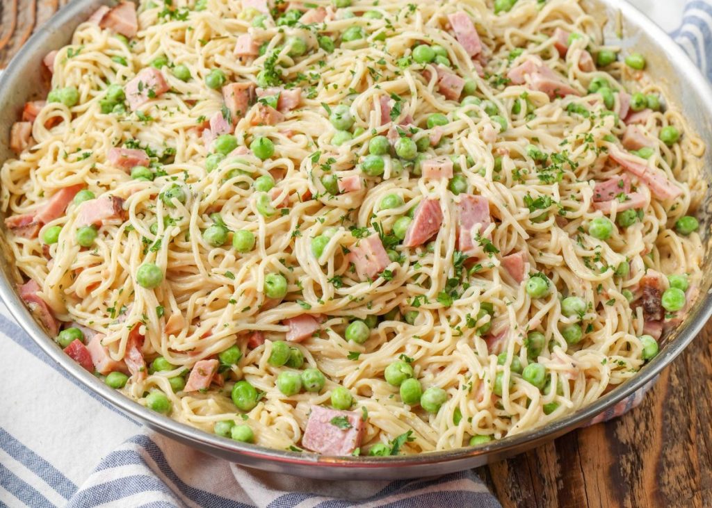 Pasta with Ham and Peas in skillet with towel underneath