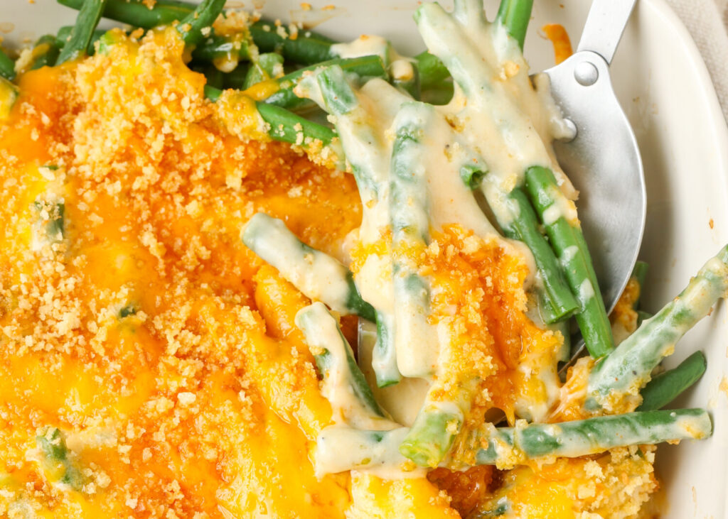 horizontal photo of green bean casserole with cheese topping