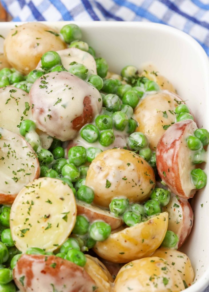 peas and potatoes with cream sauce in serving dish