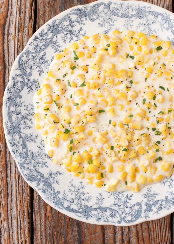 creamy corn side dish in bowl on wooden table