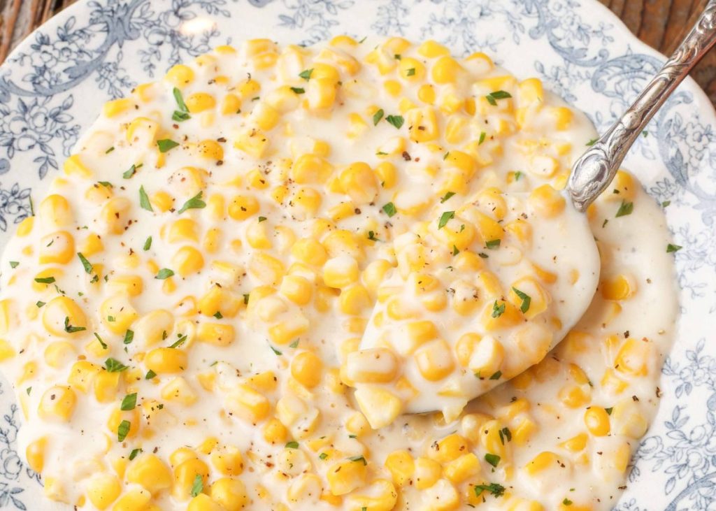 corn with cream sauce on serving spoon