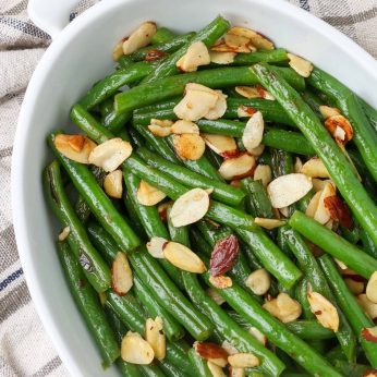 sauteed green beans in white dish with tea towel