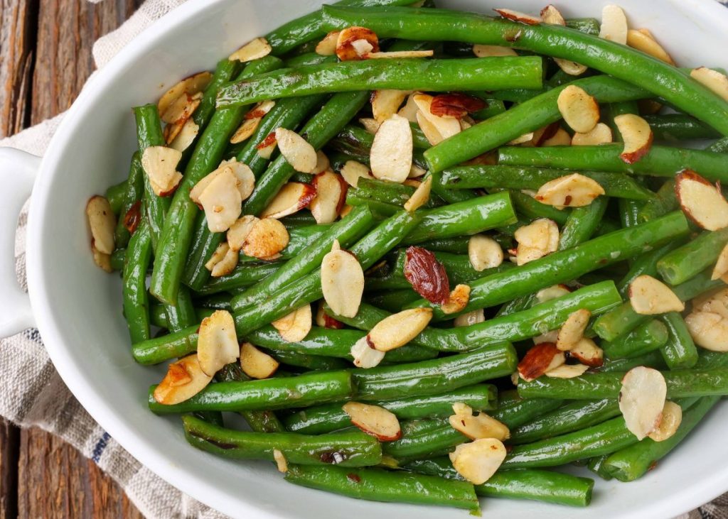 green beans with almonds in white oval dish