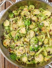 Lemon and garlic sauteed Brussels in stainless skillet with striped towel