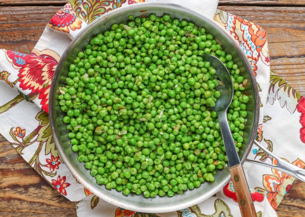 cooked peas in stainless skillet