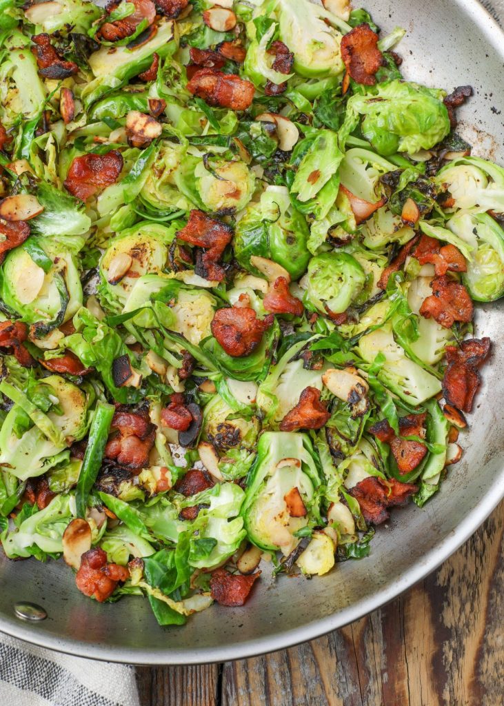 Brussels cooked with bacon and almonds in skillet with tea towel
