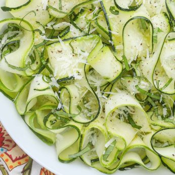 Zucchini ribbons in white bowl with linens