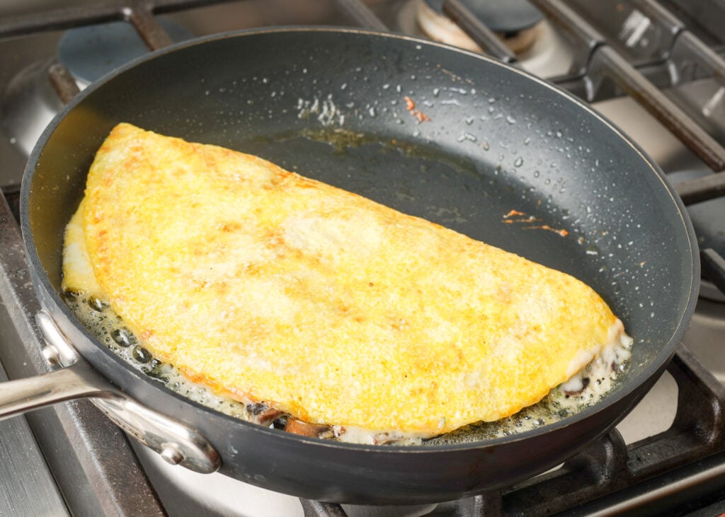 folded and filled omelet in skillet