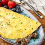 omelet filled with mushrooms on blue pottery plate